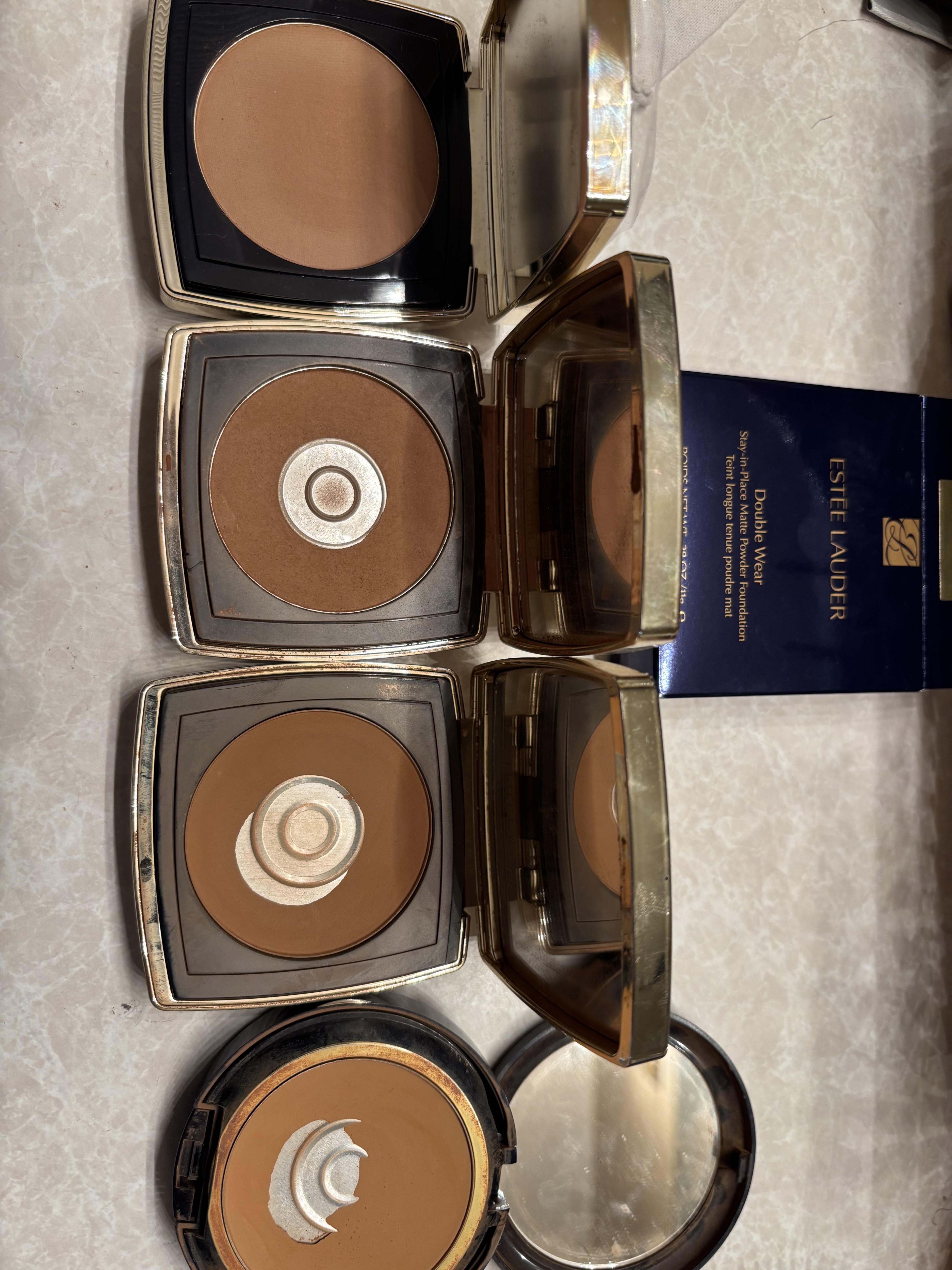 My collection of 'identical' Estée Lauder Double Wear powders. The newest 2026 batch doesn't match the older ones in color or texture.
