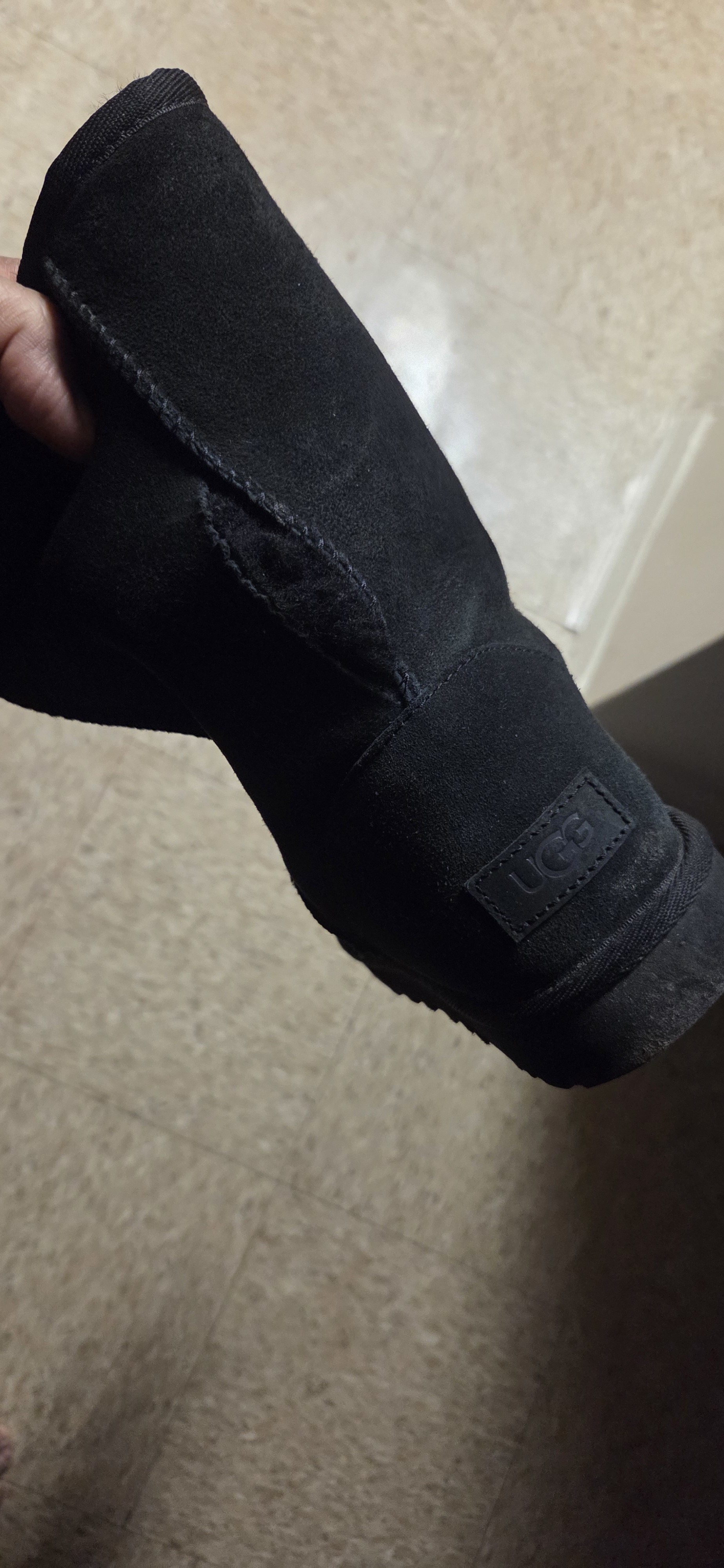 Hole in rear seam of left boot.