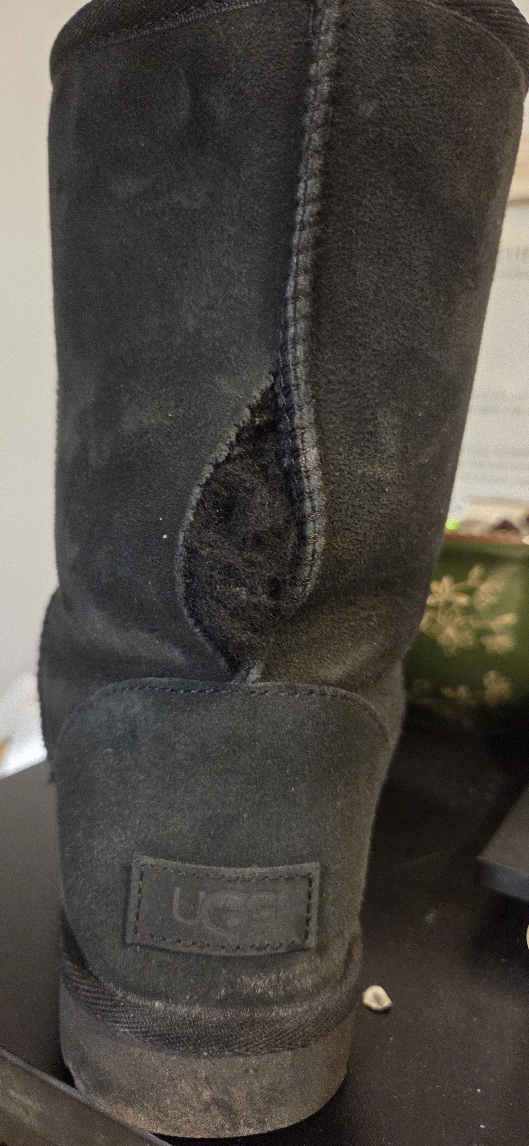 Hole in rear seam of left boot.