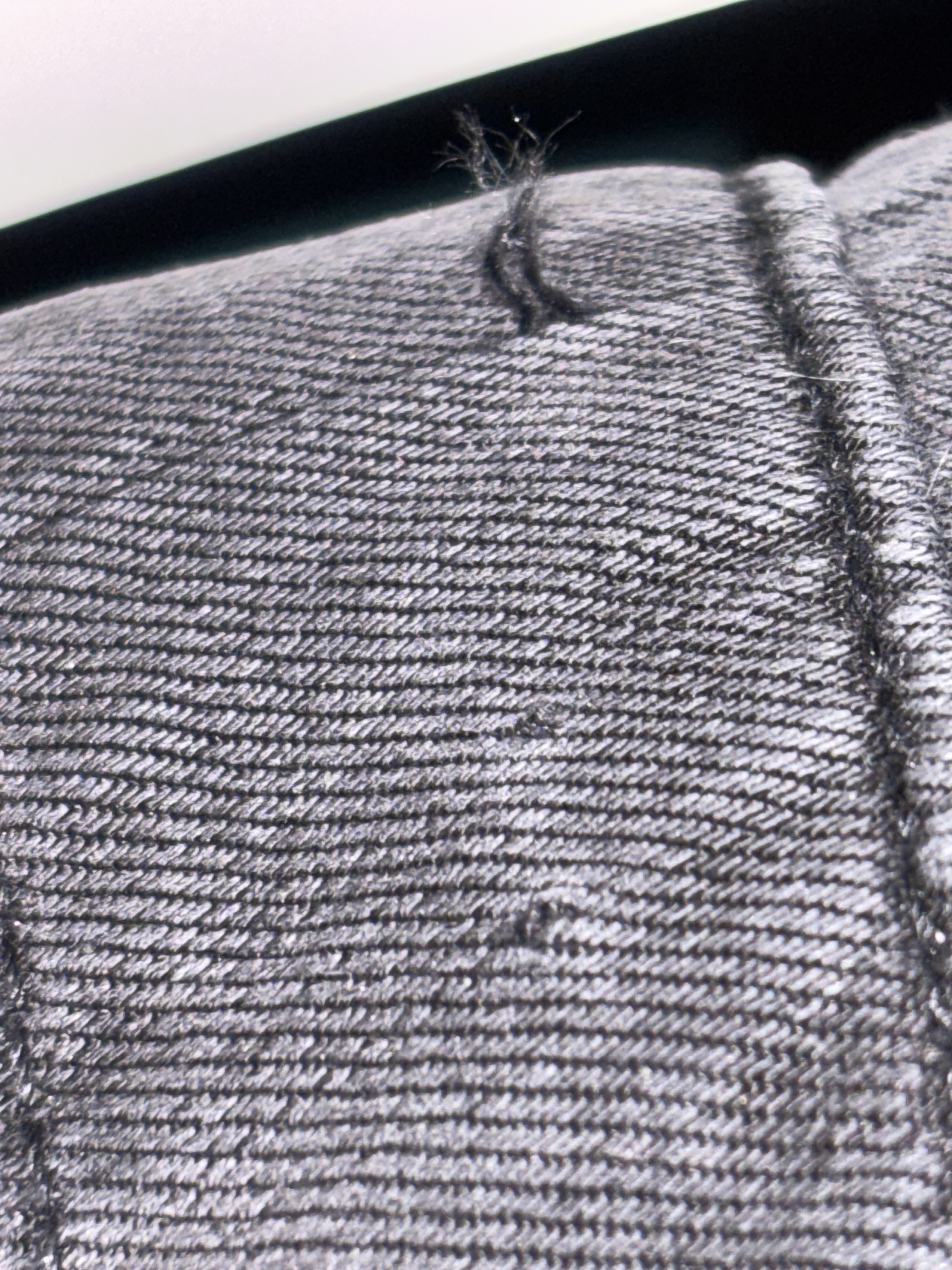 Holes and snagged fabric from the tag.