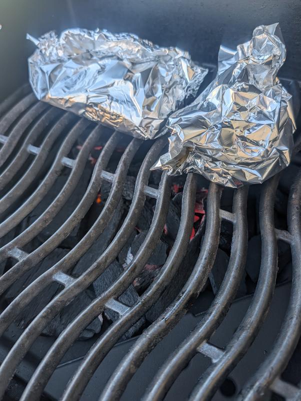 Charcoal tray in grill and food on grates