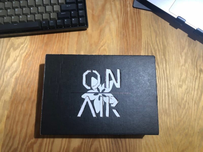 black cardboard box with "ON AIR" lettering cut out of the front-center