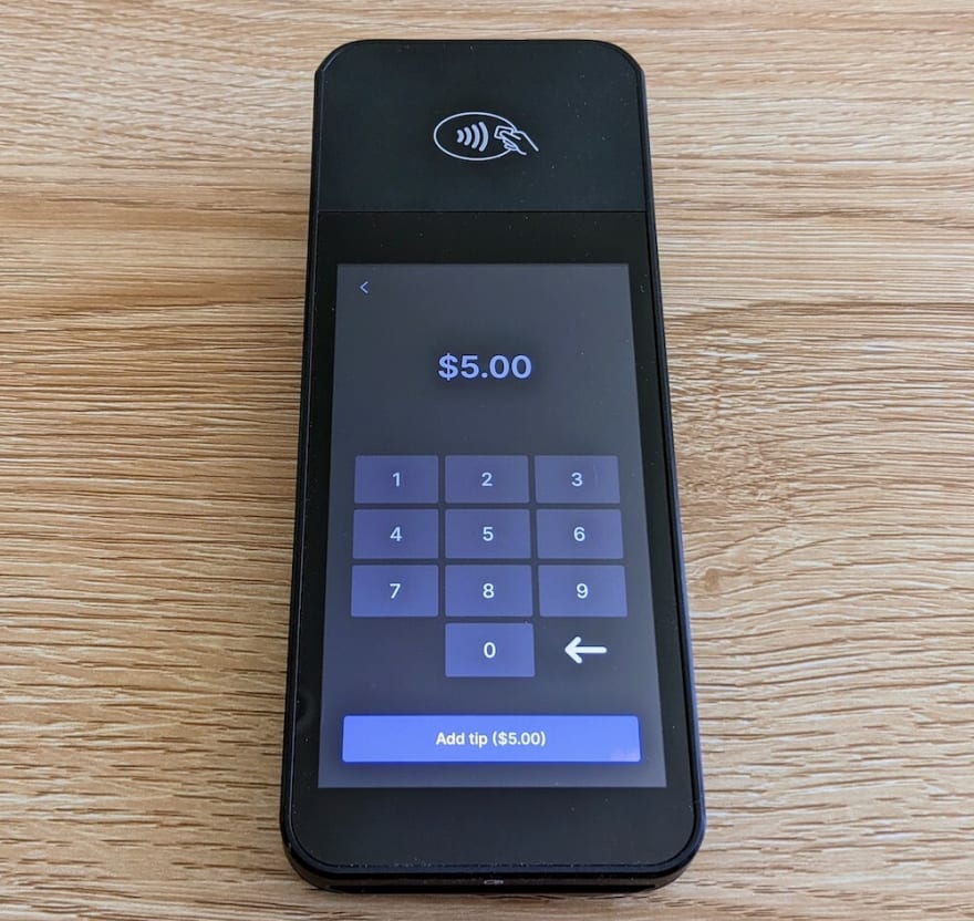 Terminal reader with screen showing a number pad to enter custom tips.