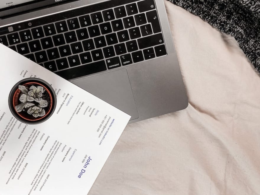A laptop and a printed curriculum vitae
