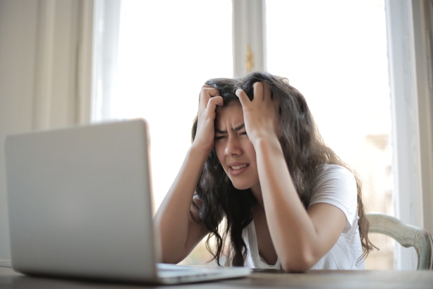 Frustrated person behind laptop