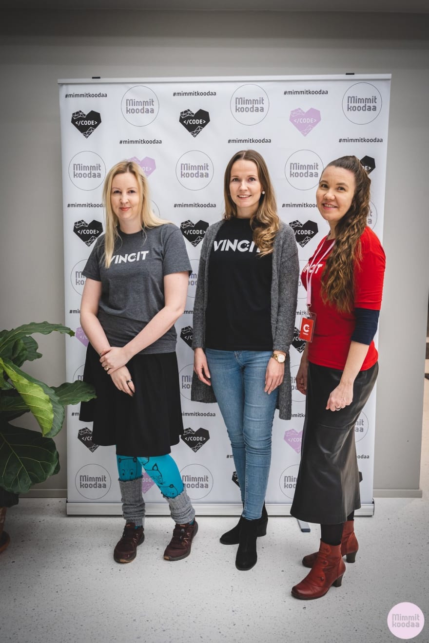 I and my two colleagues in Vincit t-shirts standing in front of Mimmit Koodaa banderol