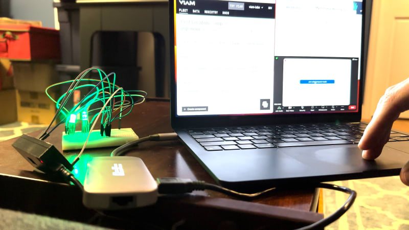 An ESP32 microcontroller connected by 4 wires to a RGB LED and USB cable to a laptop displaying the Viam web application alongside the Zoom app