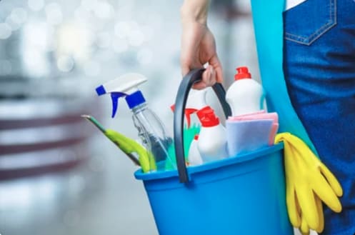 Close up of hand of person holding bucket of cleaning supplies