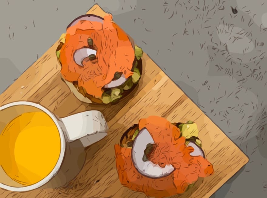 breakfast: orange juice, avocado bagel with salmon, onion and eggs