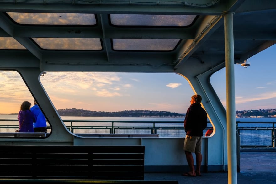 a man watches the sunset on a ferry on the puget sound