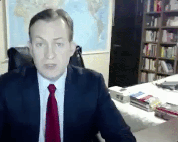 child walking in background of a man interviewing on live TV