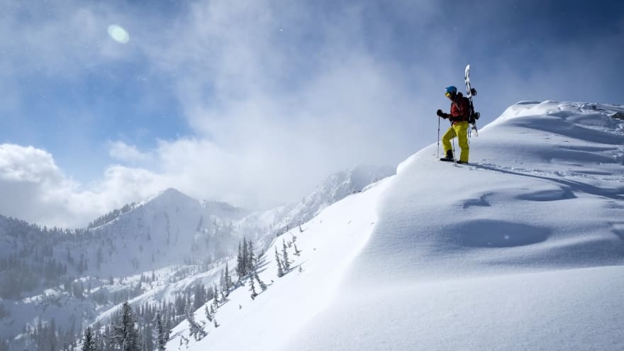 Snowboarder on the top of Mt. Millicent ready to snowboard down a sunny powder run in Northern Utah.