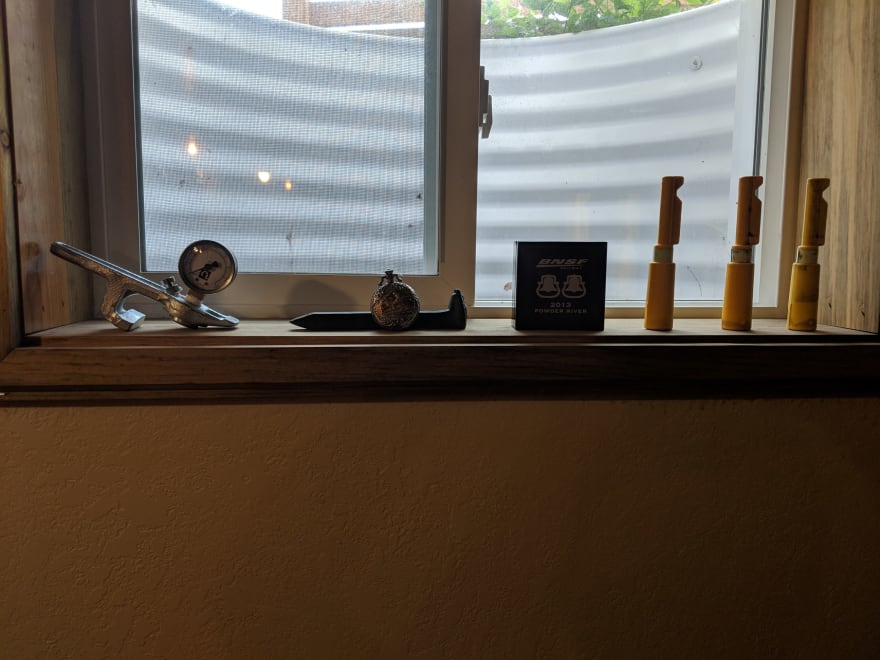 Train air gauge, railroad spike, pocket watch, BNSF award, and three locomotive reversers