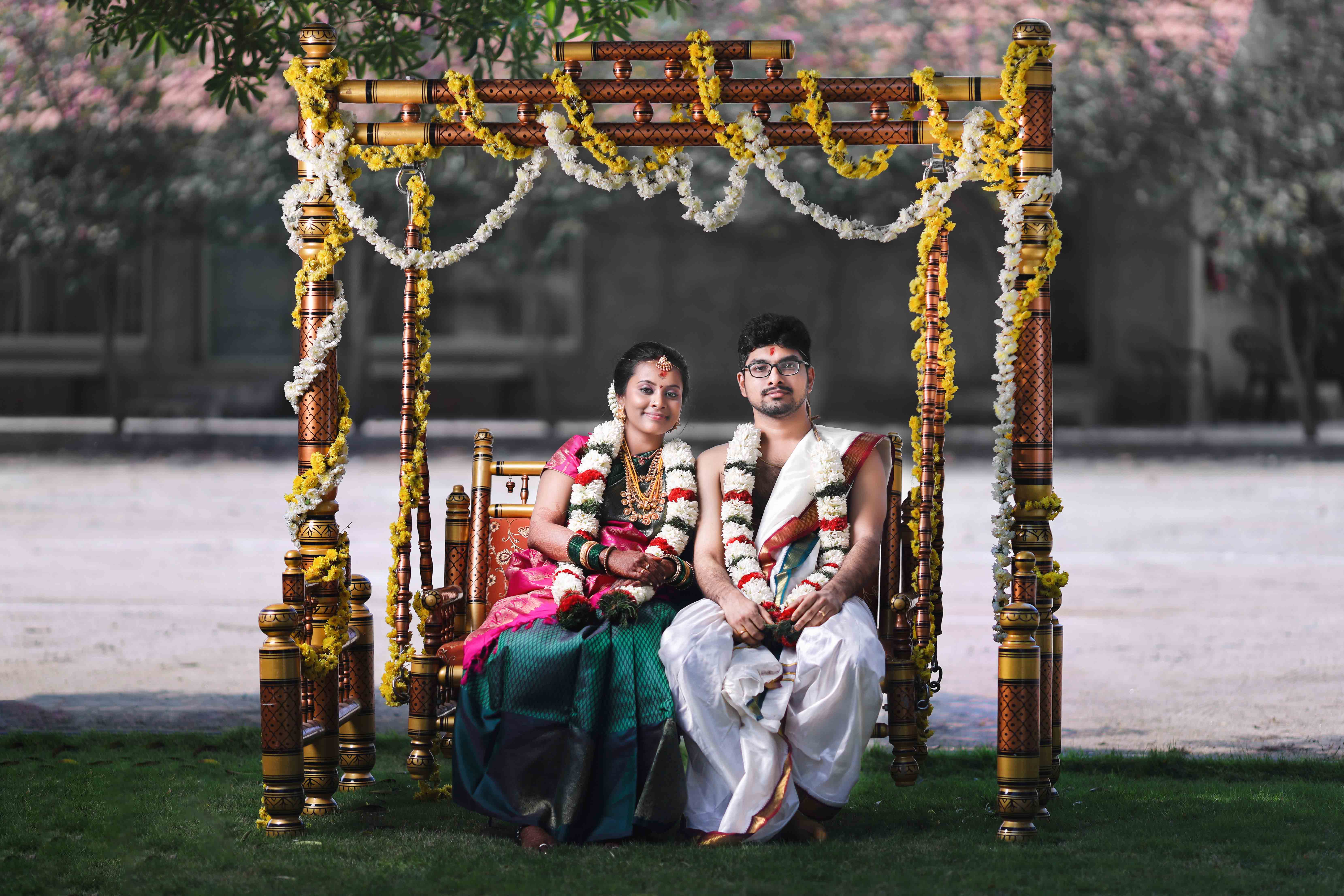 Traditional Indian wedding photography with bride and groom posing with family during ceremony