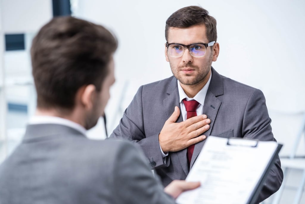 Freelance Website Developer in Mumbai 7 Serious man in suit and eyeglasses gesturing and looking at businessman with clipboard, business