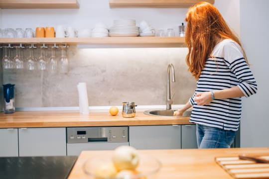 A photo of a woman cleaning the kitchen