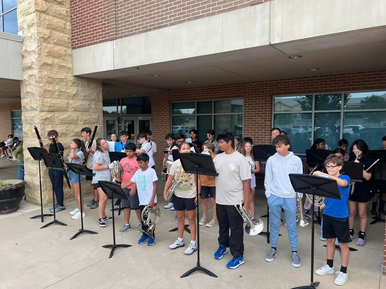 Band students performing outside of a school.