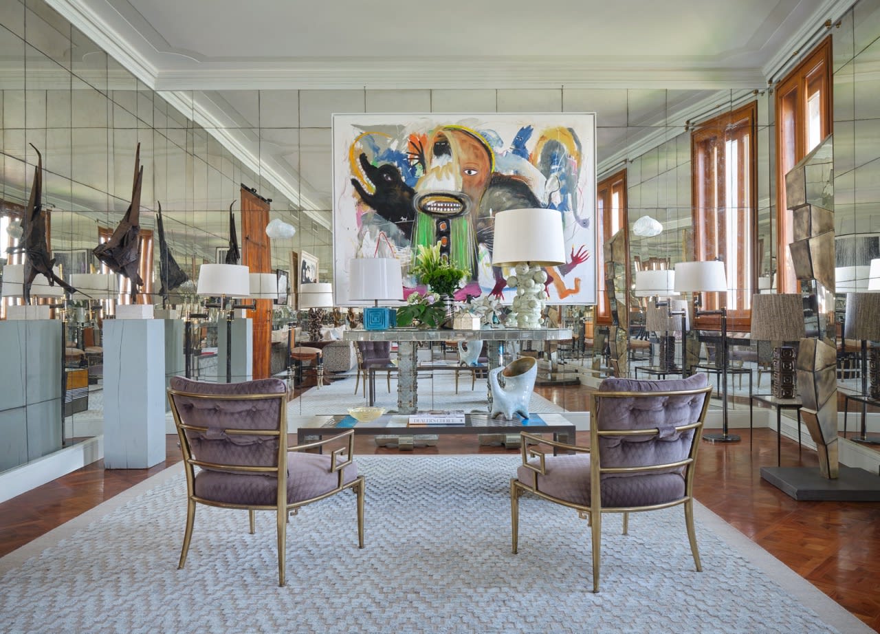 Salon de la Palazzina Fortuny à Venise réaménagé par Chahan Minassian, avec murs de miroirs anciens, fauteuils en velours mauve et laiton et tableau figuratif coloré.