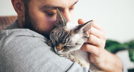 A Man Cuddling A Cat