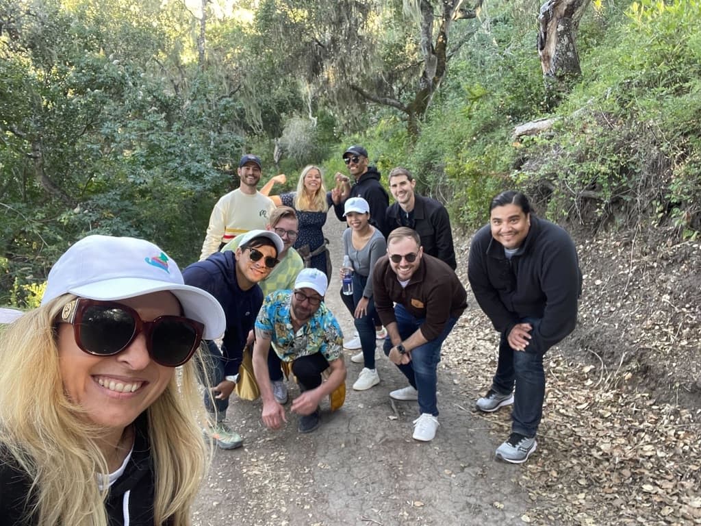 Group of PrettyLitter crews posing on a hiking trail in a forest