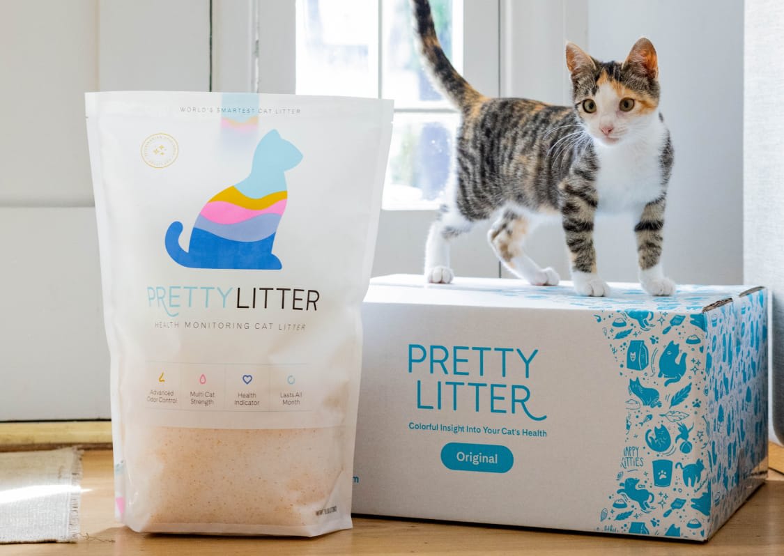 PrettyLitter package and bowl of litter with paw prints and scooper