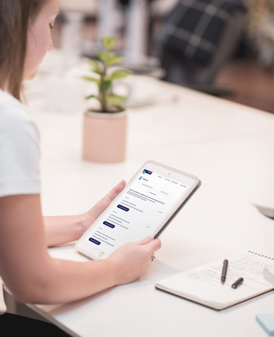 The side view of a person holding an iPad with a prototype displaying on screen