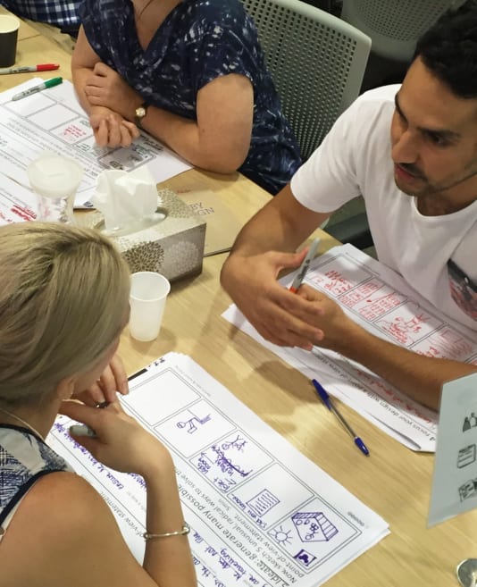 People sitting opposite each other discussing wireframes