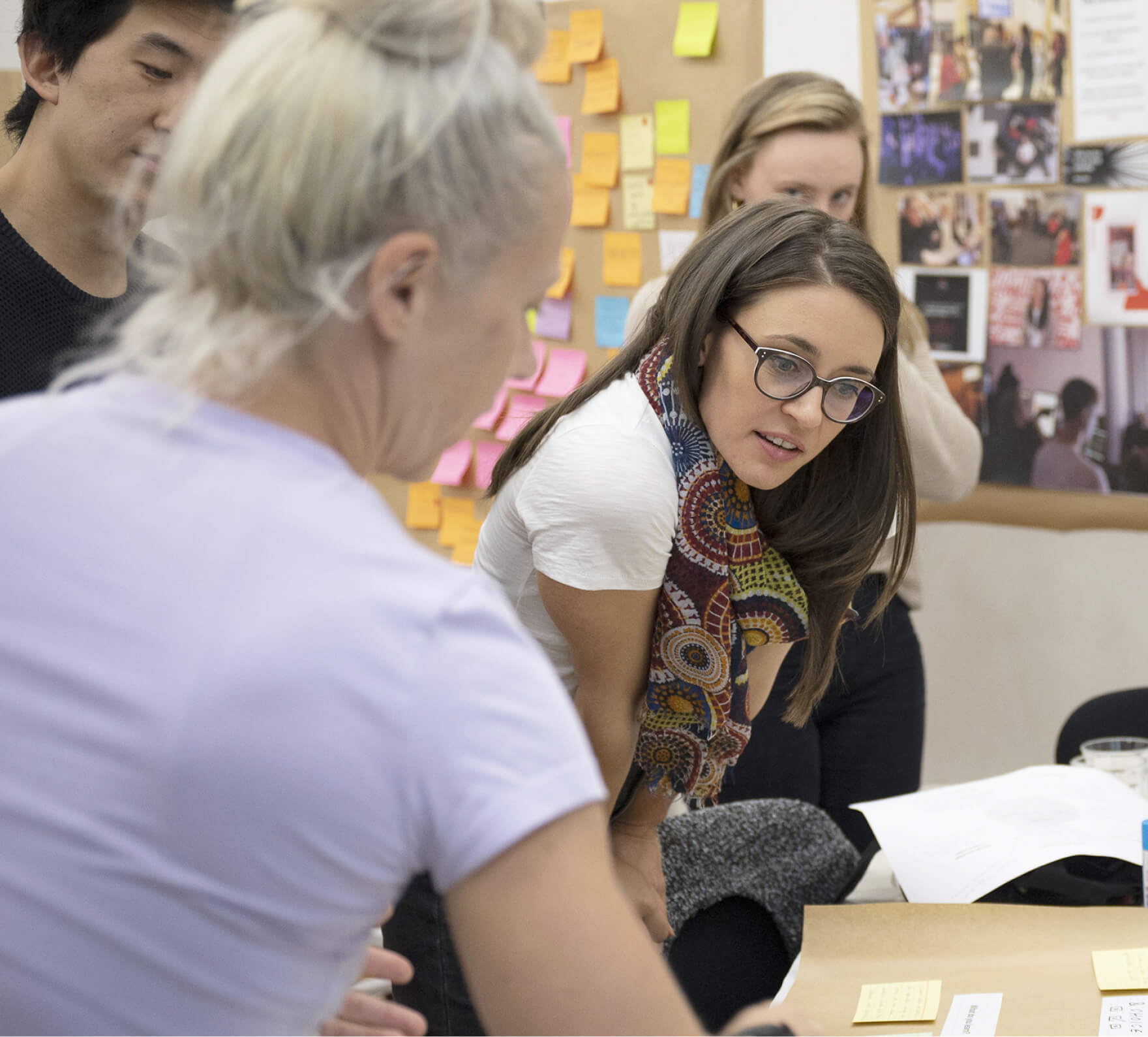 small group of people read a paper on a desk