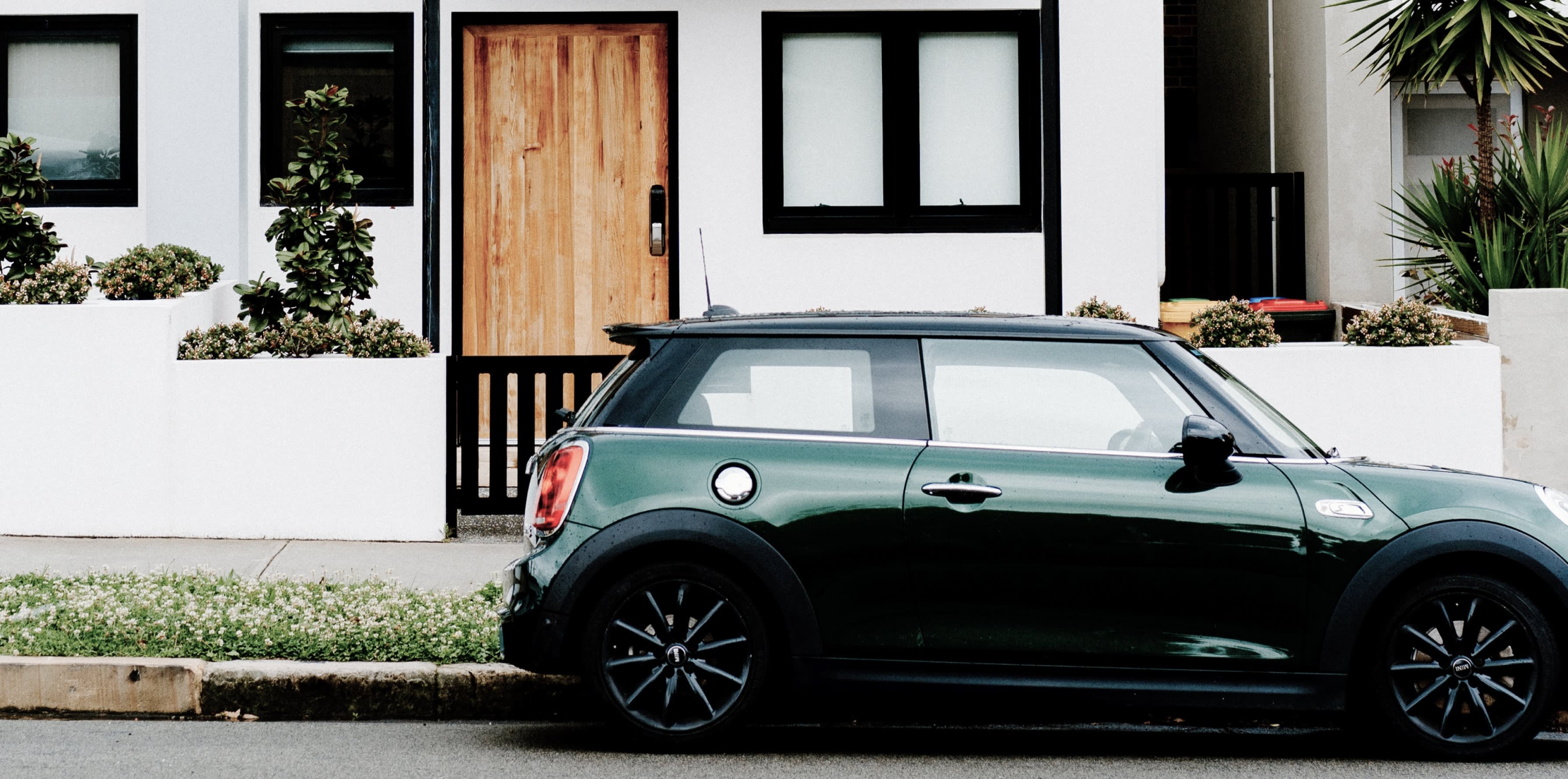 Green car parked in front of house