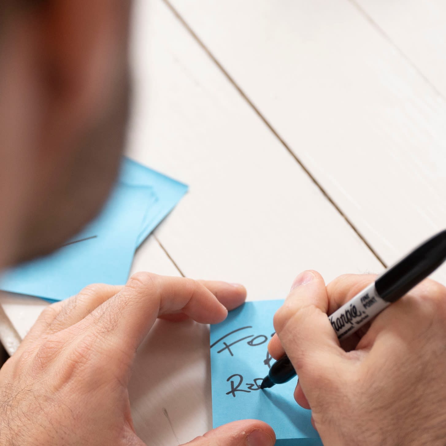 Person writing on a sticky note