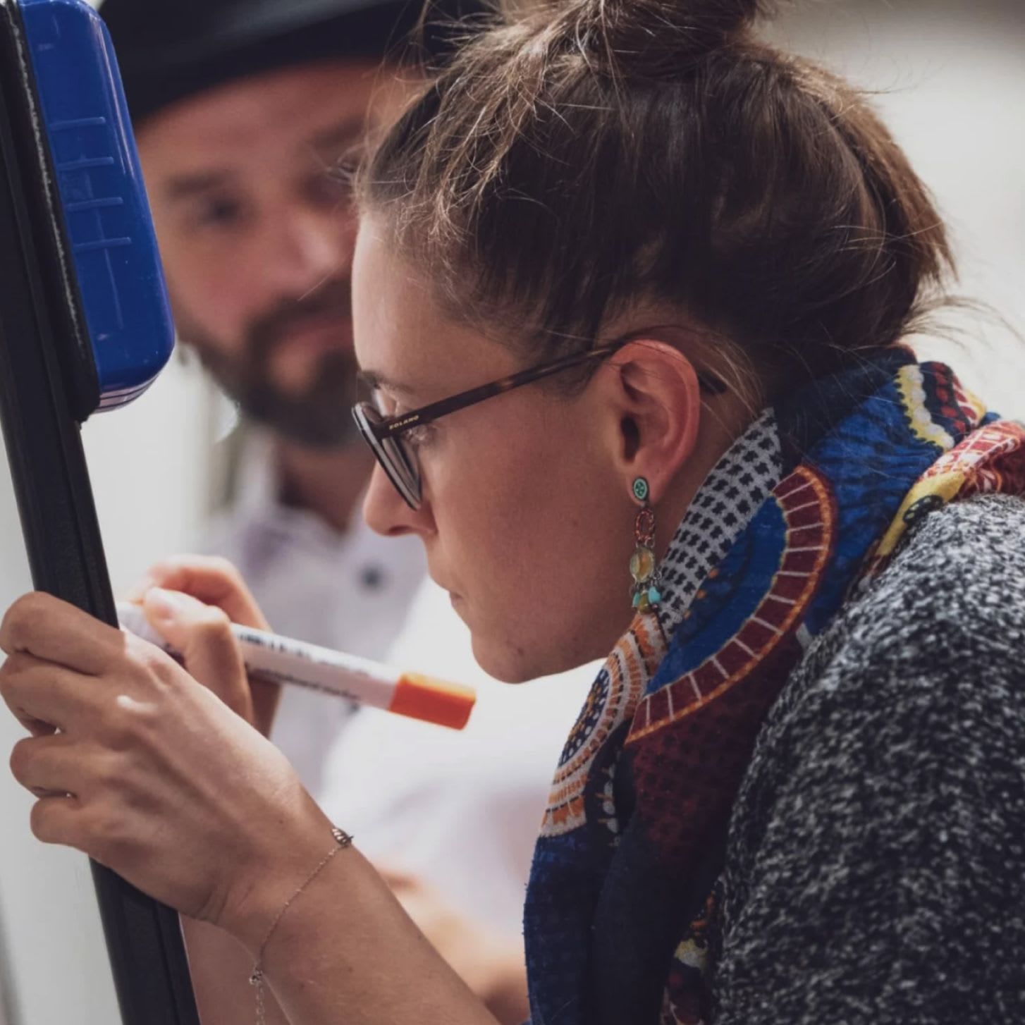 Close up of a woman writing on a whiteboard