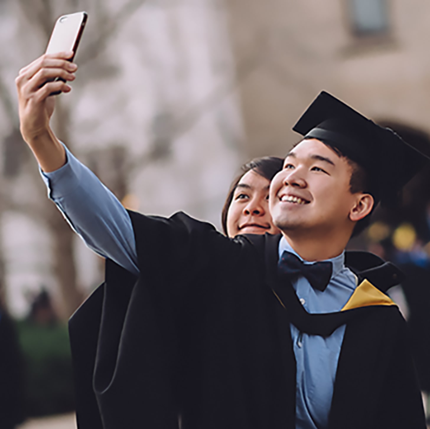 Student wearing a graduation ceremony gown taking a selfie