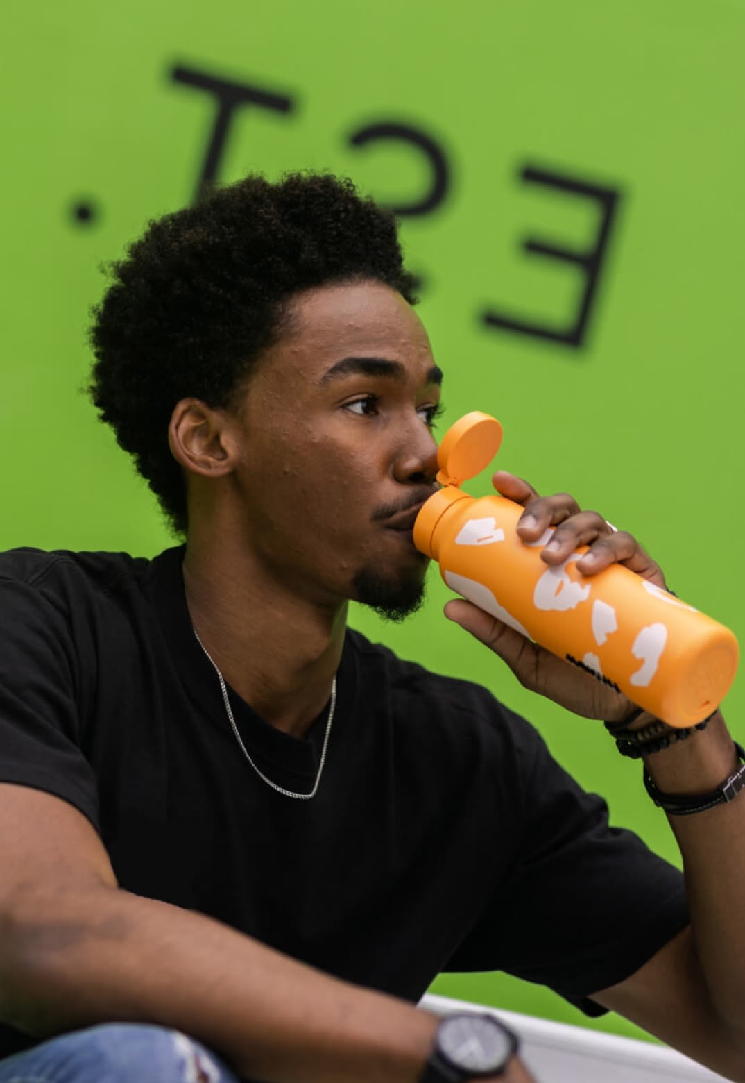 A young man drinking out of a water bottle