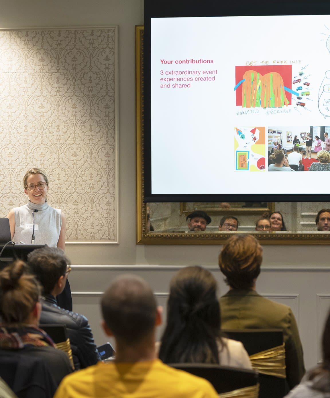 Group of people listening in on a talk from a person at the front