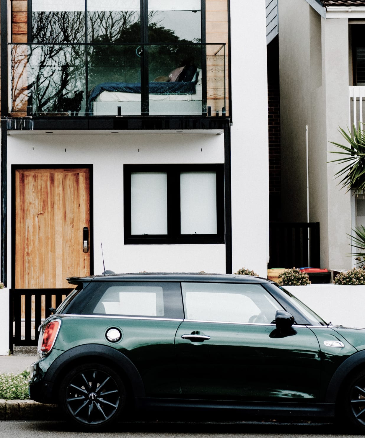 A small car parked in front of a residential building