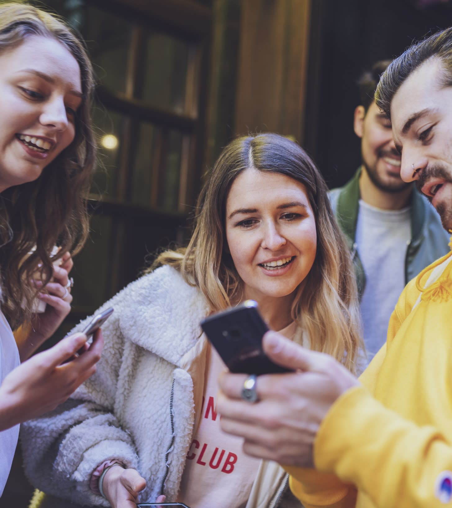 Group of people looking on at a phone screen