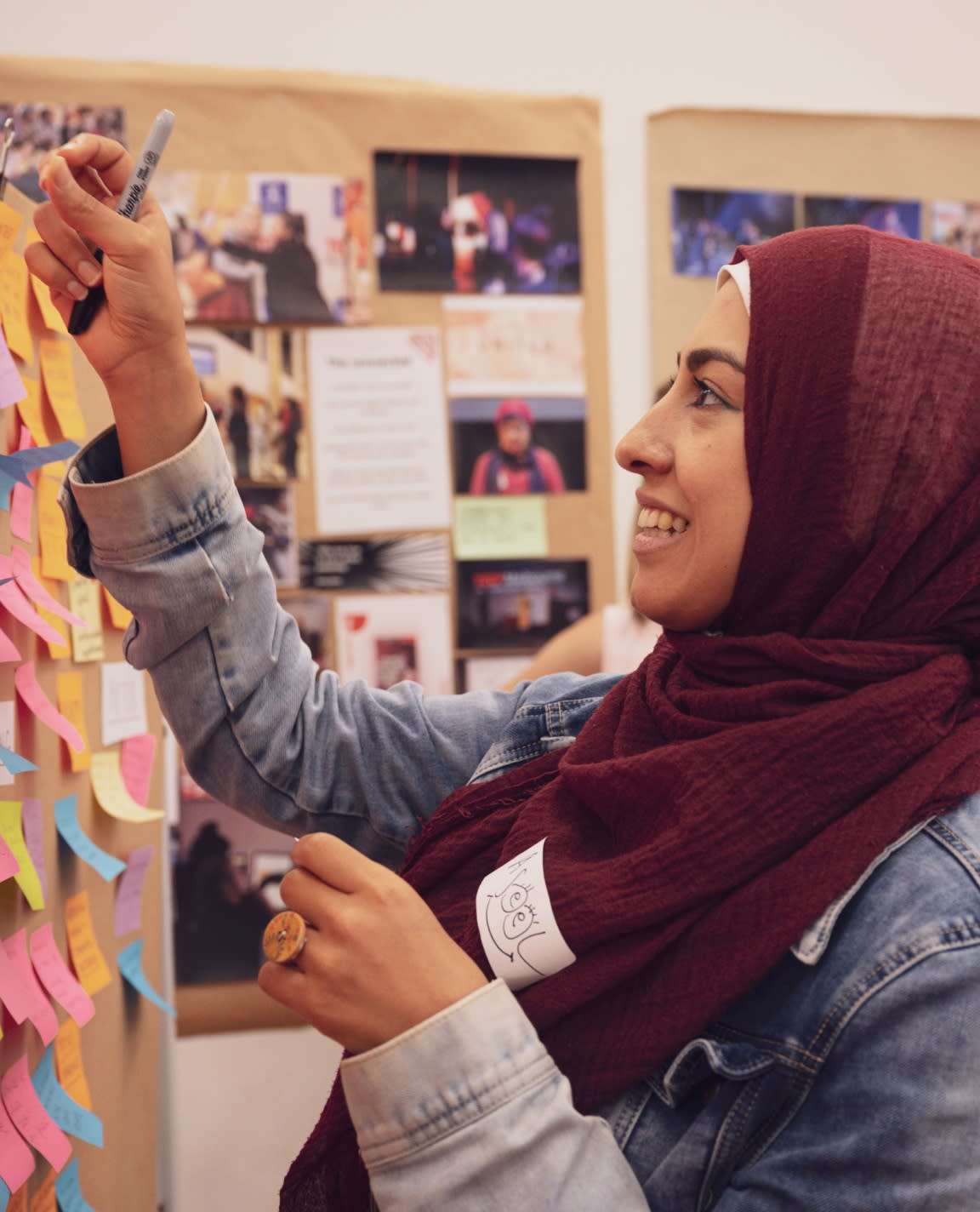 Person holding a post it note from a board of post it notes