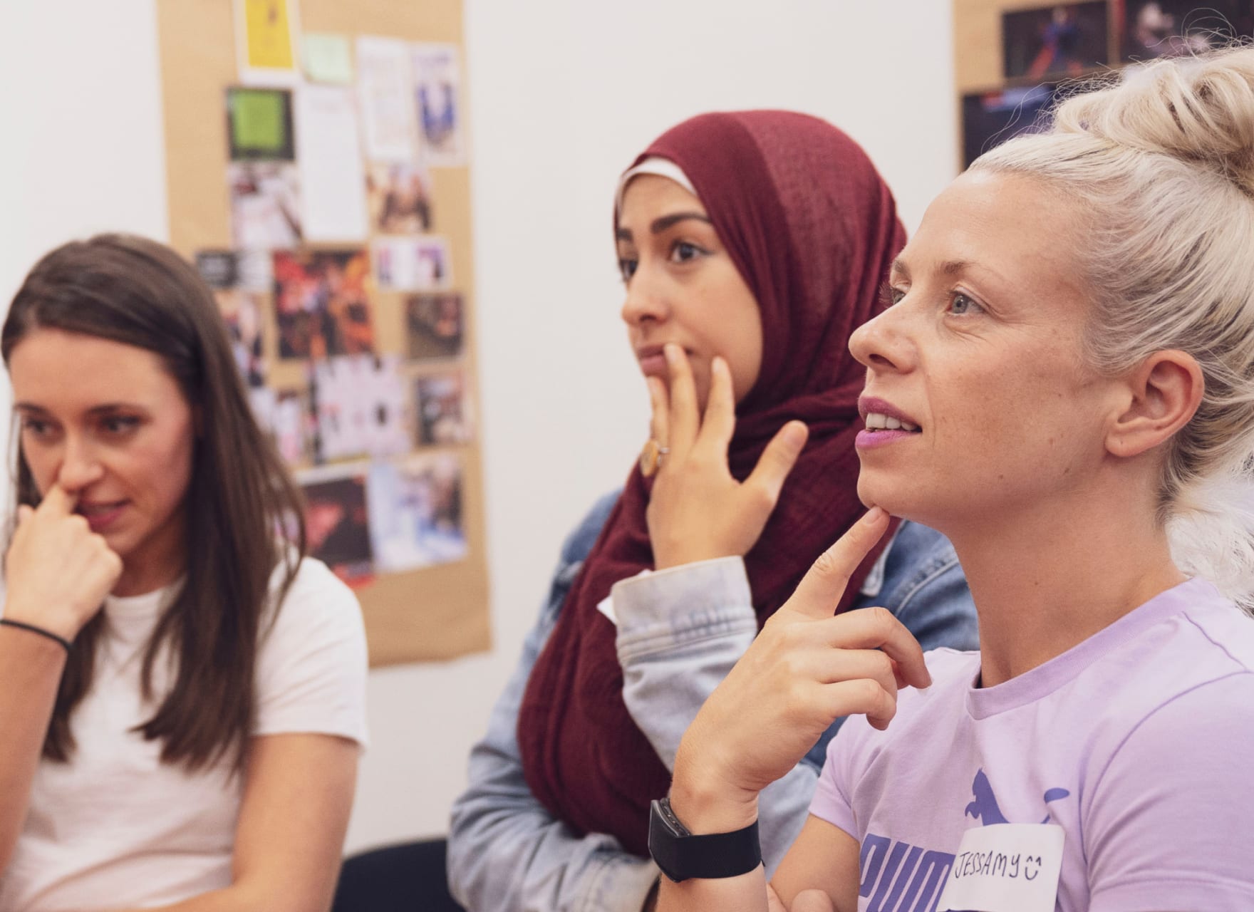 Group of women looking at a presentation, the room is filled with design concepts