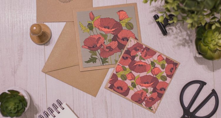 papel para imprimir convite em uma mesa com caderno, tesoura e plantas