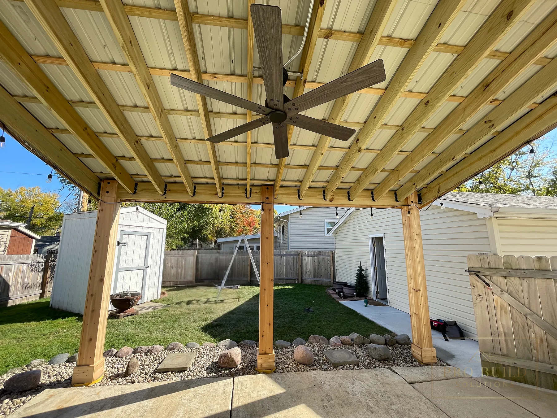 Ceiling fan and covered seating area beneath custom pergola