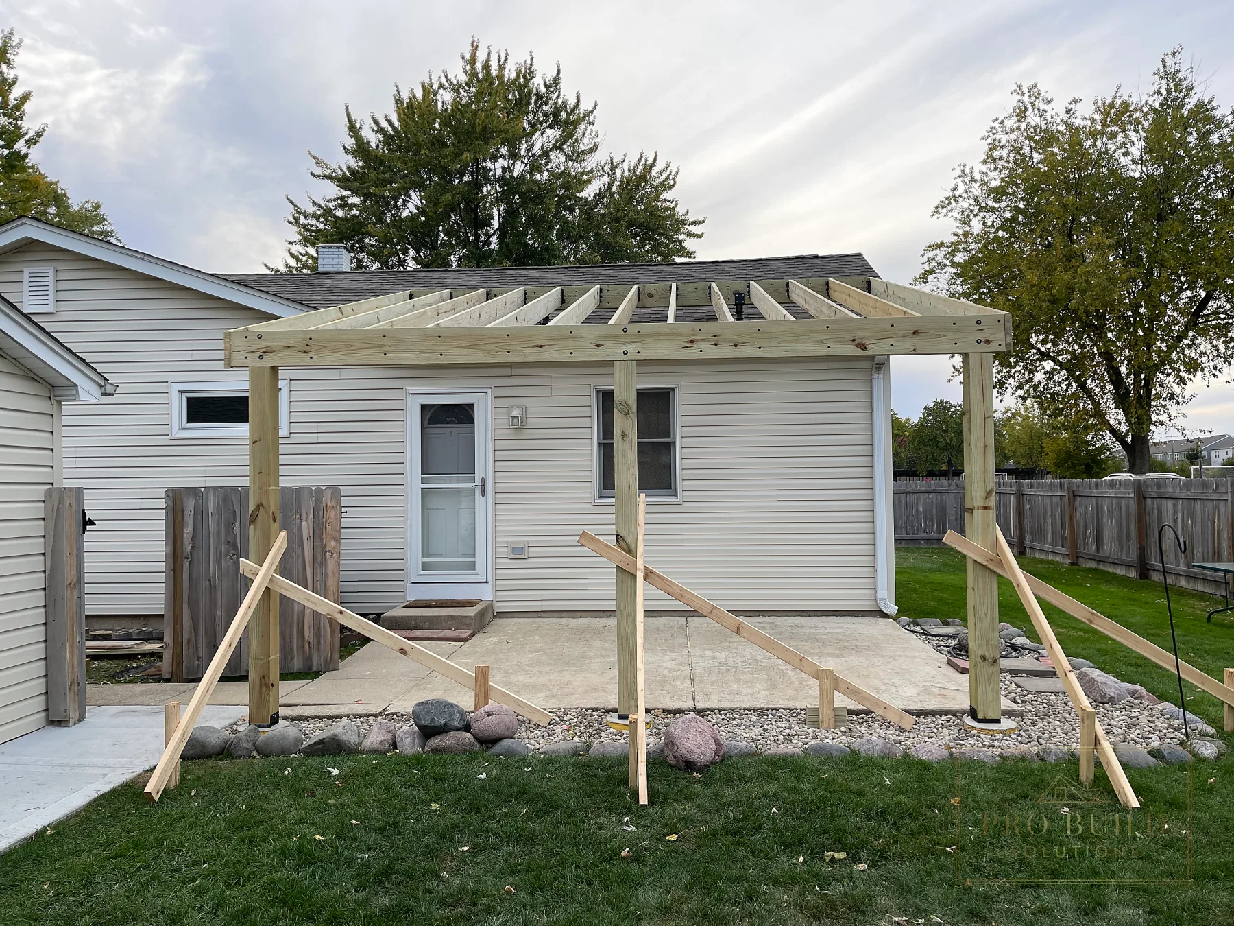 Structural framing and raised roof connection for custom covered pergola