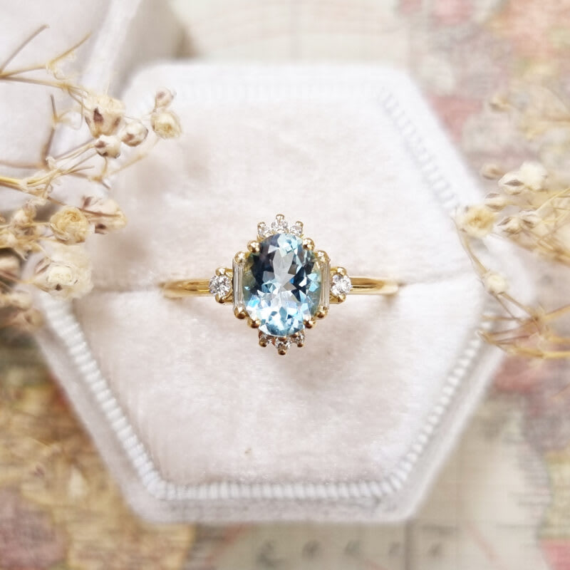 Oval aquamarine and diamond cluster ring in 18ct yellow gold