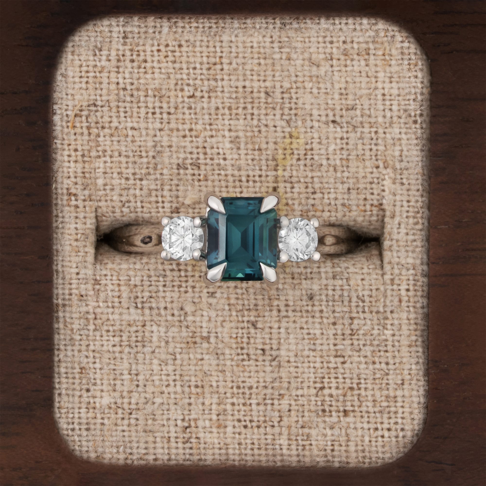 Emerald cut teal sapphire and diamond trilogy ring