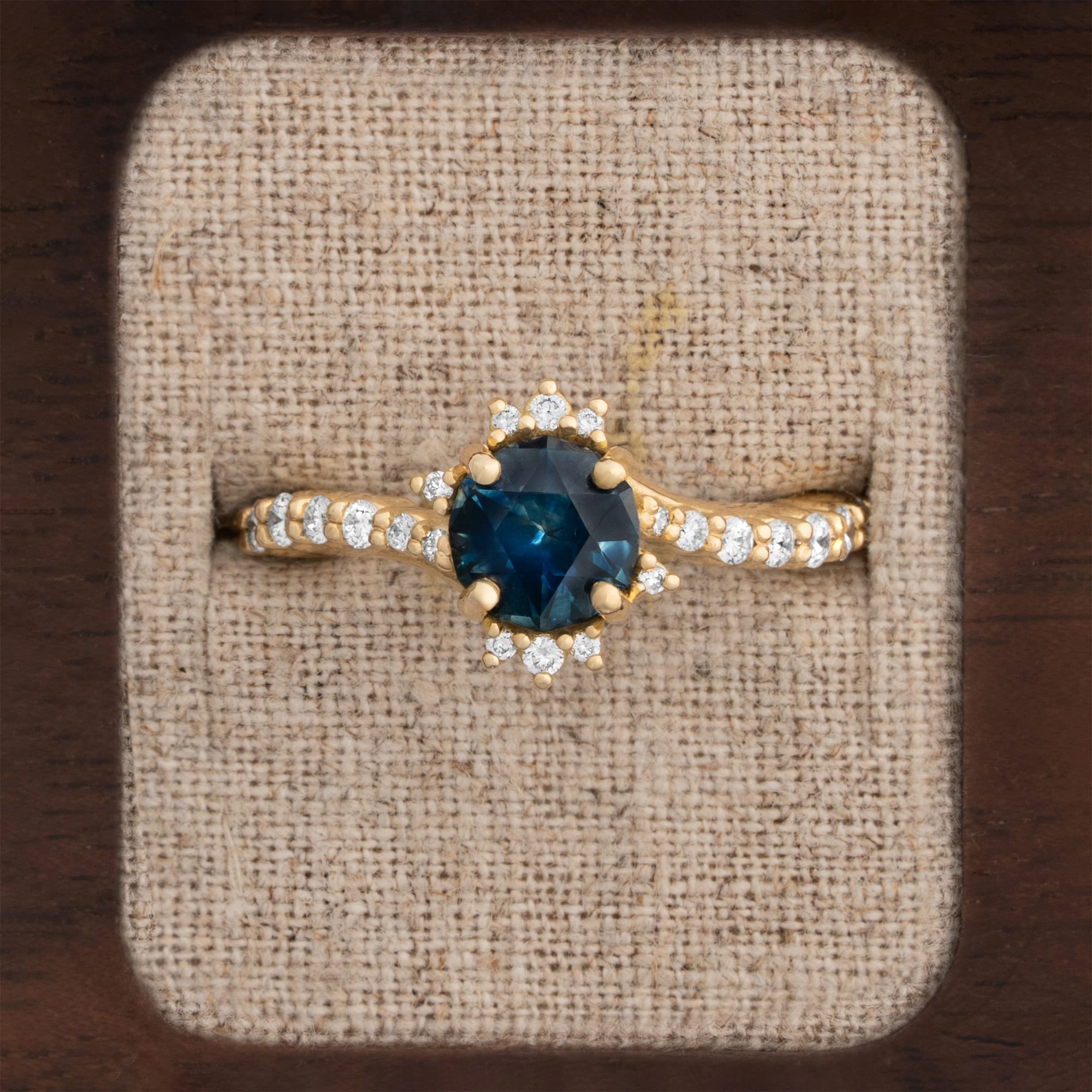 Intense precision cut deep teal sapphire and diamond twist ring