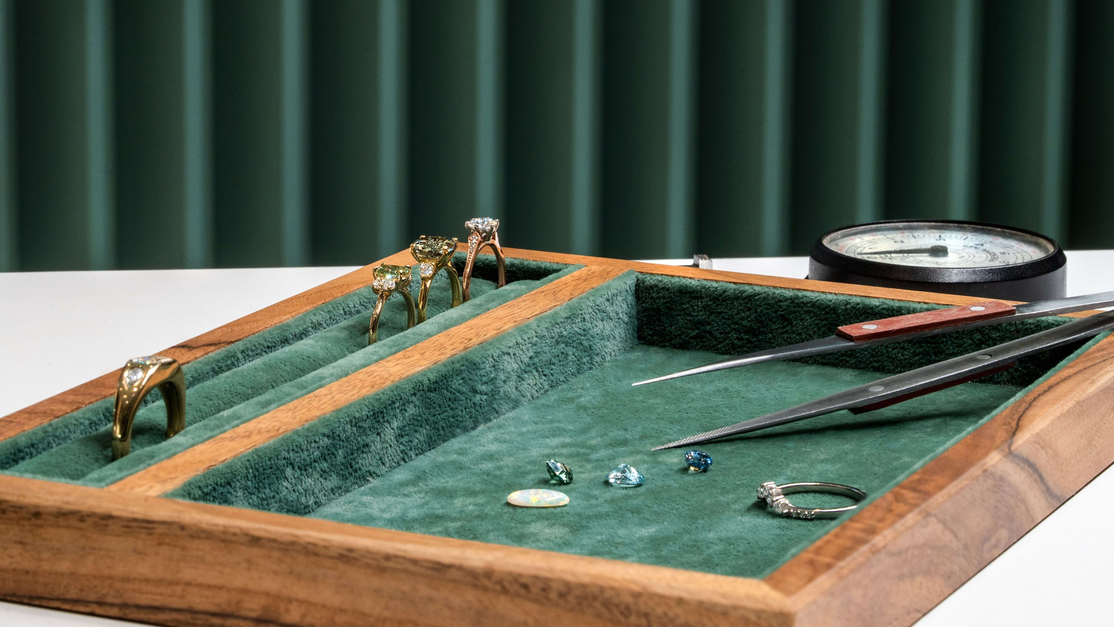 A selection of rings and loose gems on a jewellery display tray