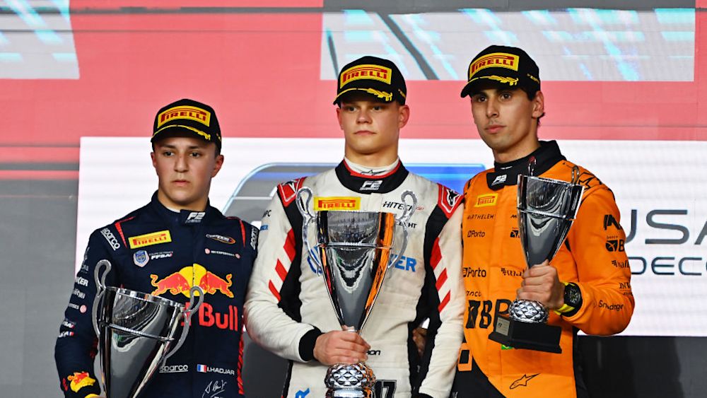 The top three drivers celebrate on the podium after the Feature Race