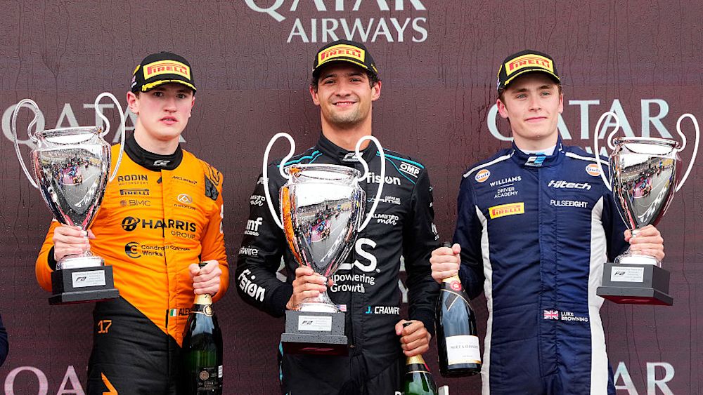 The top three celebrate on the podium after the race