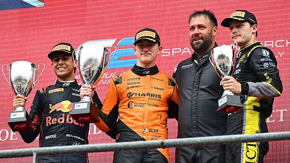 The top three celebrate on the podium after the race
