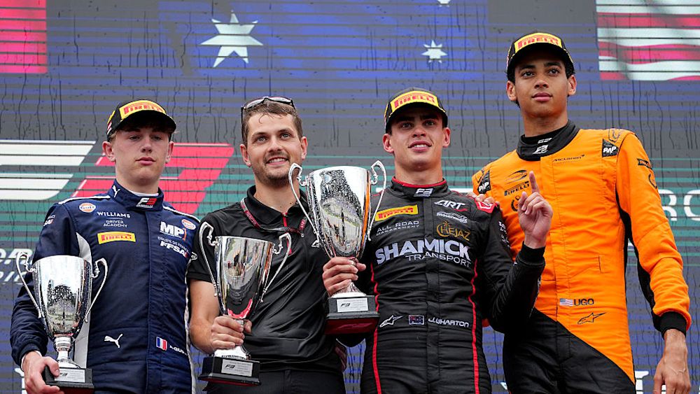 Los tres primeros pilotos celebran en el podio después de la carrera.