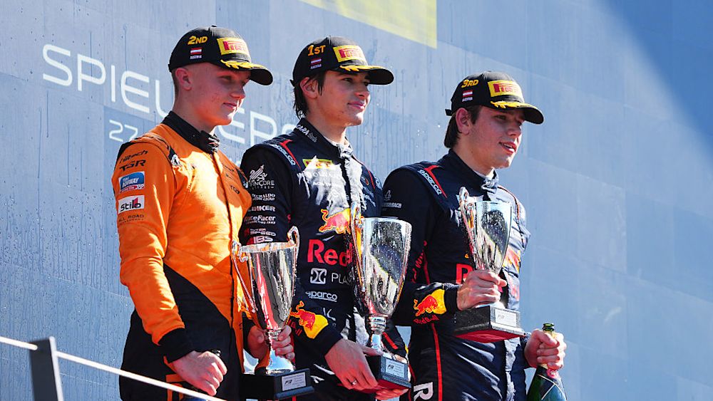 The top three drivers celebrate on the podium after the race